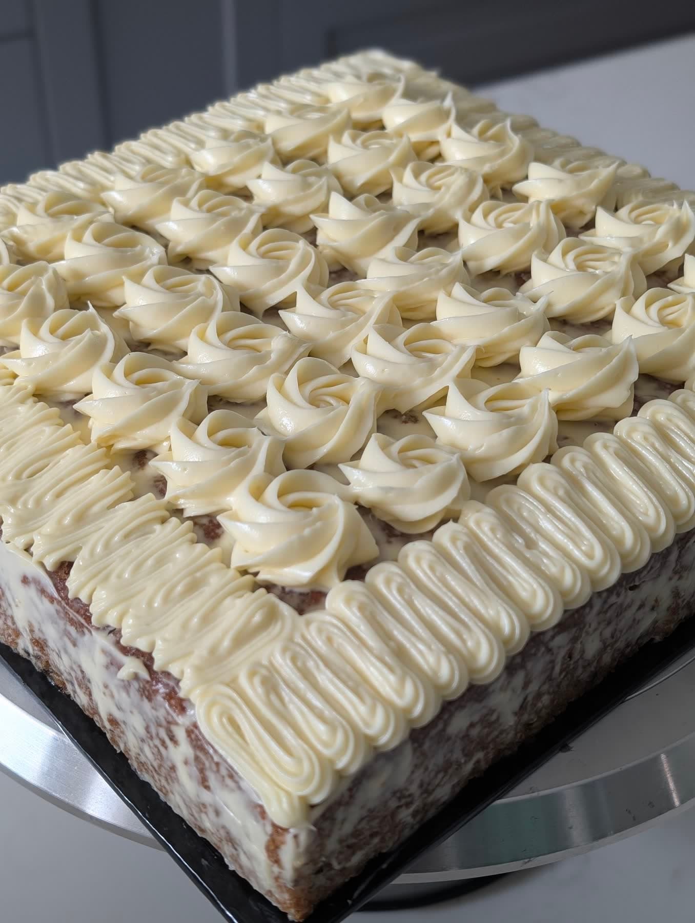 A square cream cake covered in piped rosettes, finished in the Basic Cakes class