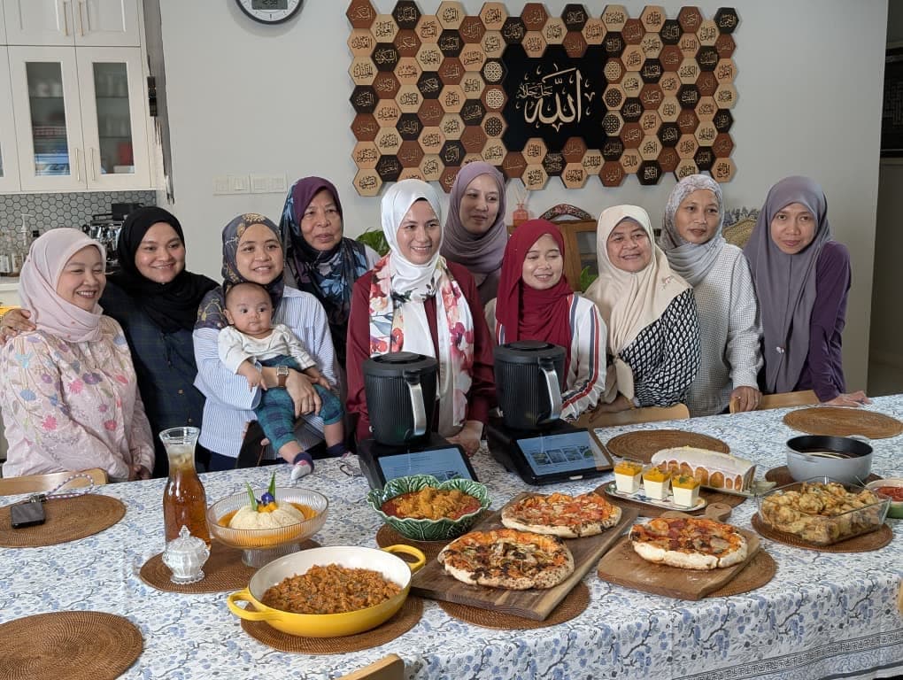 The class gathered around a table of finished dishes, with two Thermomix® machines