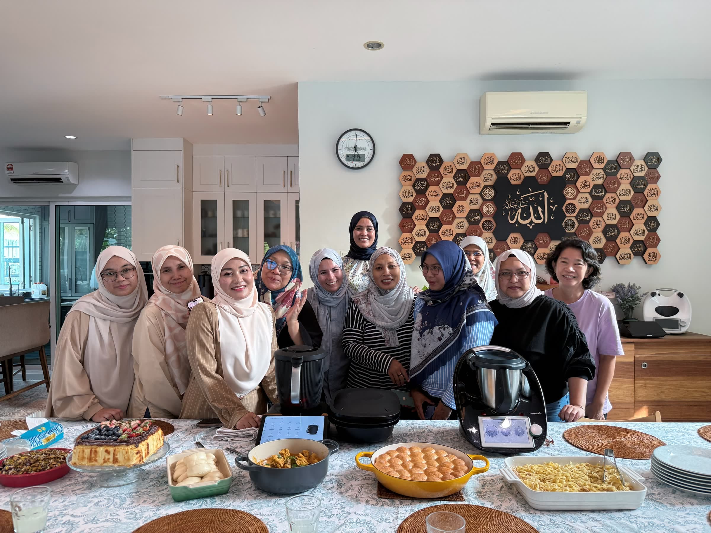 A CooknShare class group behind a table of dishes they cooked together, with two Thermomix® machines on the table
