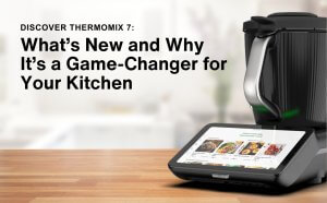 Thermomix 7 on a kitchen countertop with ingredients and accessories, showcasing its sleek design and multifunctional features.