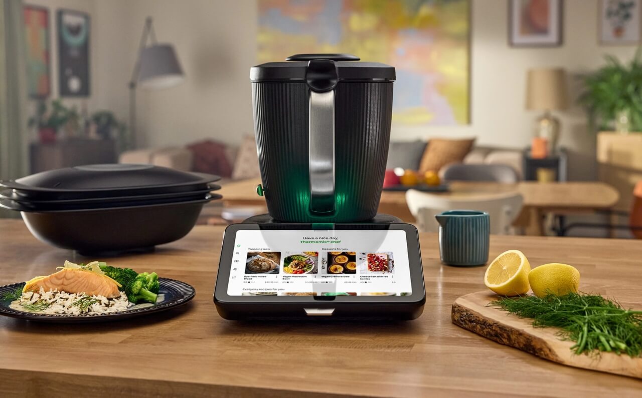 Thermomix 7 device displayed with beautifully plated dishes, showcasing the variety of meals that can be effortlessly prepared with it.